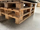 a large pile of wooden pallets sitting in a warehouse
