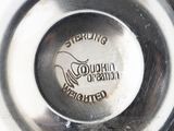a close up of a silver plate with a logo on it