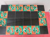 un carrelage noir et orange orné de motifs verts et rouges