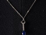 a woman wearing a necklace with a blue and white stone pendant