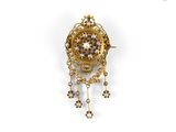 a close up of a gold and diamond broochle on a white background