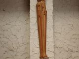 a wooden statue of a person on a shelf in a room