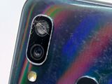 the back of a cell phone with a broken camera lens on it