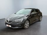 Une voiture noire est garée dans une pièce aux murs blancs.
