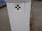 a white trash can sitting on a pallet in a warehouse