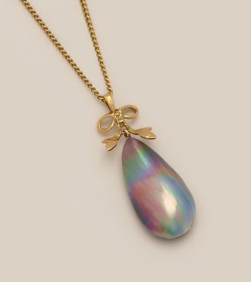 une photo d'un collier avec un pendentif en forme de larme suspendu à une chaîne en or