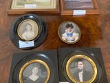 several framed portraits of people are on display on a table