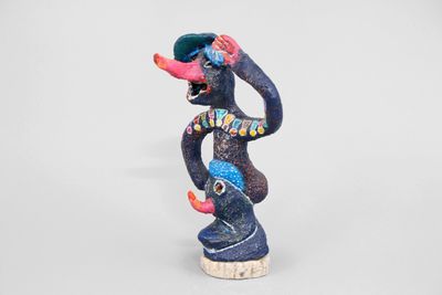 figurine of a monkey with a hat on his head on a white background