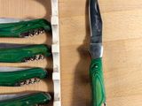 five knives and a knife holder on a wooden table