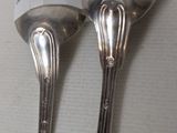 two spoons that are sitting next to each other on a table