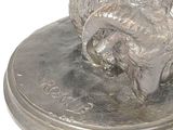 a silver statue of a ram on a base