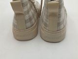 the back of a pair of beige sneakers with a white and beige checkered pattern