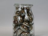 a glass jar filled with chocolate candies on a white surface