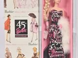 une poupée dans une boîte rose, vêtue d'une robe noire et blanche et d'une étole en fourrure