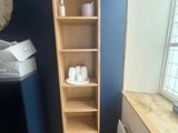 a wooden shelf in the corner of a room