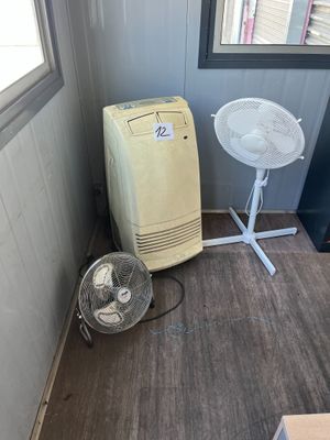 a small room with a fan and a table in it