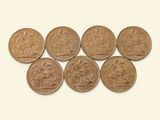 six pièces de monnaie de tailles et de formes différentes posées sur une surface blanche