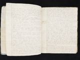 an open book with writing on it sitting on top of a black surface