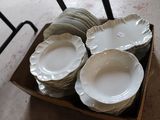 many plates and bowls in a box on the floor