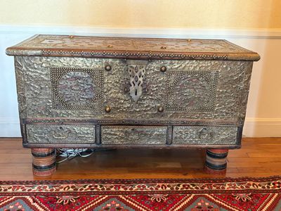 a silver chest sitting on top of a red rug