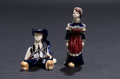 deux figurines représentant une femme et un homme assis l'un à côté de l'autre
