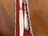 a knife, fork and spoon in a box on a table