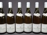 six bouteilles de vin sont alignées sur une table