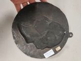 a person holding a metal plate with a picture on it