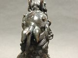 bronze statue of a dog with flowers on its head
