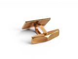 a close up of a pair of gold cufflinks on a white background