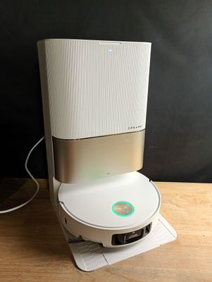 une enceinte blanche et argentée posée sur une table en bois