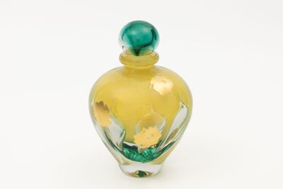 une bouteille en verre jaune avec un bouchon vert