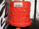 un gâteau rouge posé sur une étagère noire, à côté d'une boîte à motif zébré
