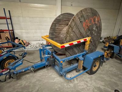 a picture of a forklift with a large cable reel attached to it