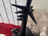 a black sculpture on a table next to a red dragon