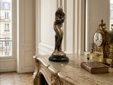 a statue of a woman standing on a table in a room