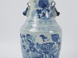 a blue and white vase sitting on a white surface