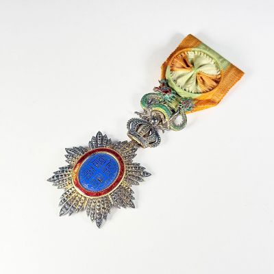 une image représentant une médaille ornée d'une pierre bleue au centre