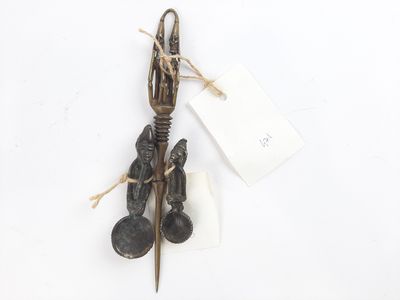 a metal spoon and spoon rest with a tag attached to it