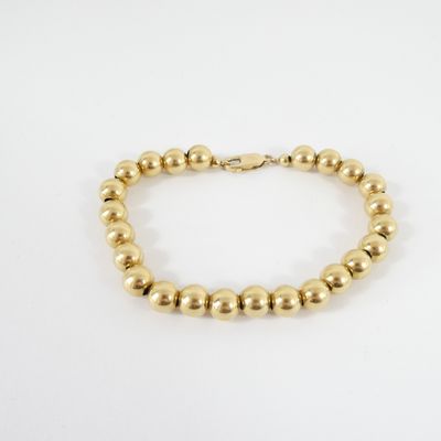un bracelet orné de perles dorées sur fond blanc