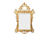 un miroir au cadre doré ouvragé accroché à un mur blanc