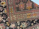 an image of a very old rug laying on top of a white floor