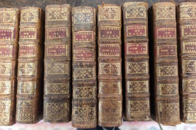 de nombreux livres anciens empilés les uns sur les autres sur une table