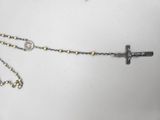 a close up of a necklace with a cross on it