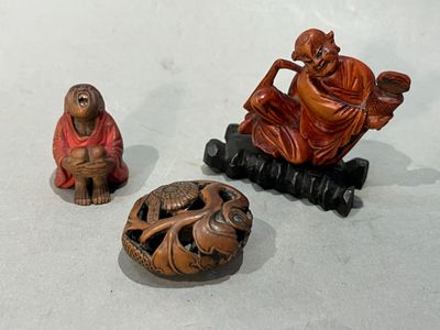 trois figurines représentant un homme et un singe assis sur un banc