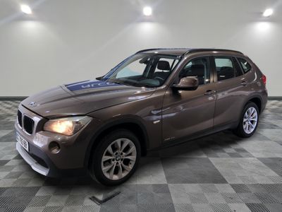 la bmw x1 est garée dans une grande pièce au sol en damier