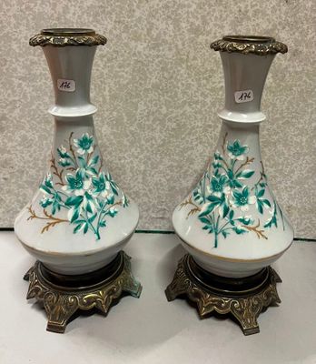 une paire de vases blancs et dorés ornés de fleurs vertes