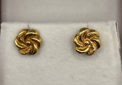 une paire de boucles d'oreilles dorées dans un coffret cadeau
