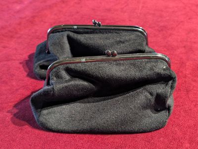 two black purses sitting on a red carpet