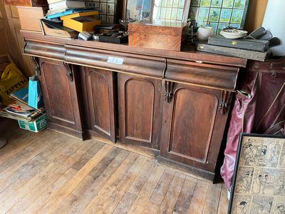 a wooden cabinet with a lot of items on top of it